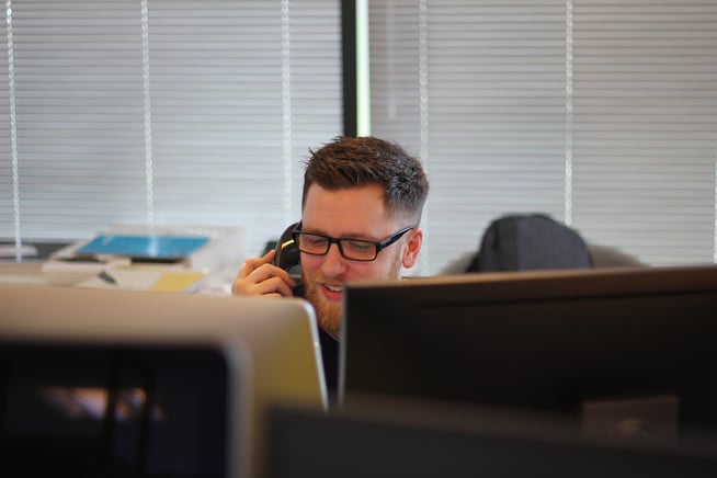 man with computers answering phone call